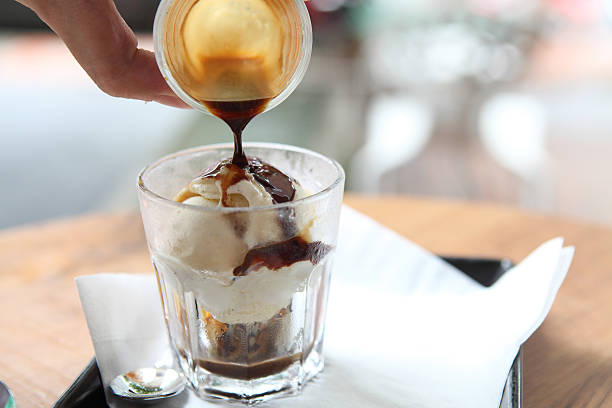 hand pouring coffee over ice cream to make an italian affogato
