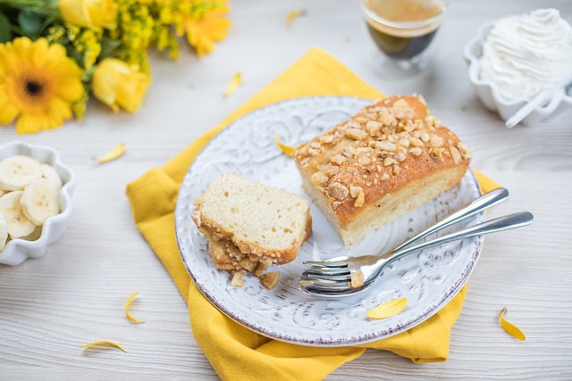 a loaf of coffee cake on a plate with flowers and slices of banana