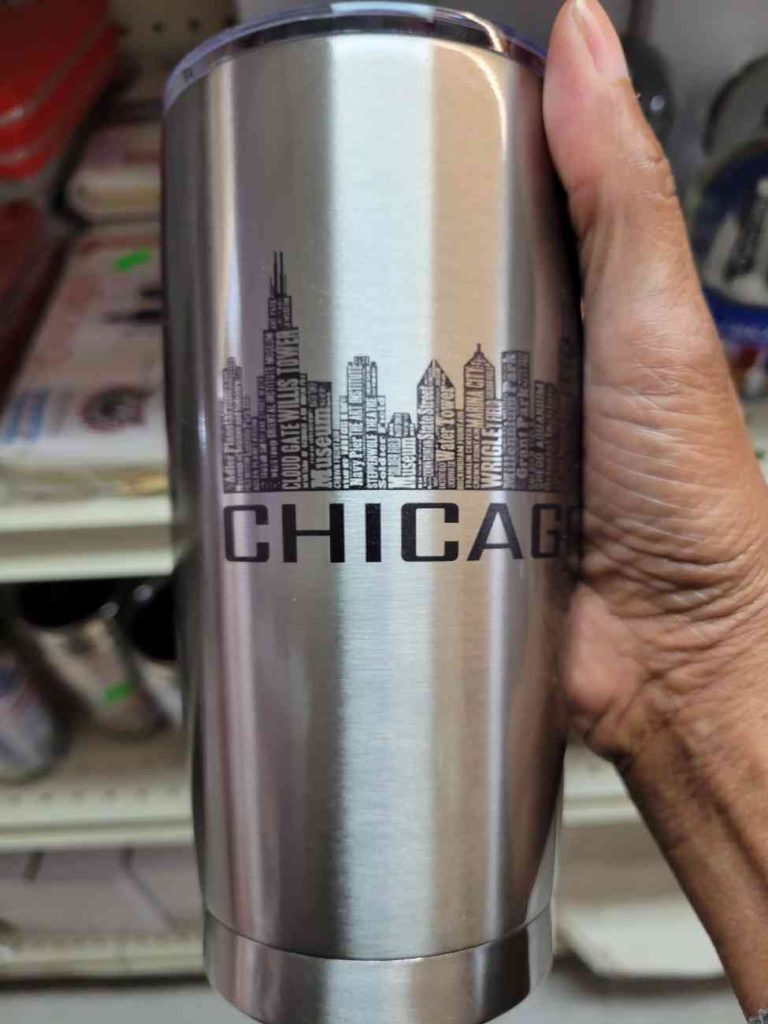 hand holding a stainless steel coffee tumbler