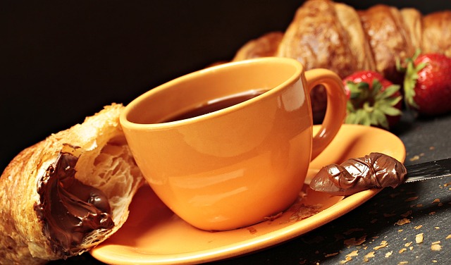 a yellow coffee cup with chocolate filled croissants