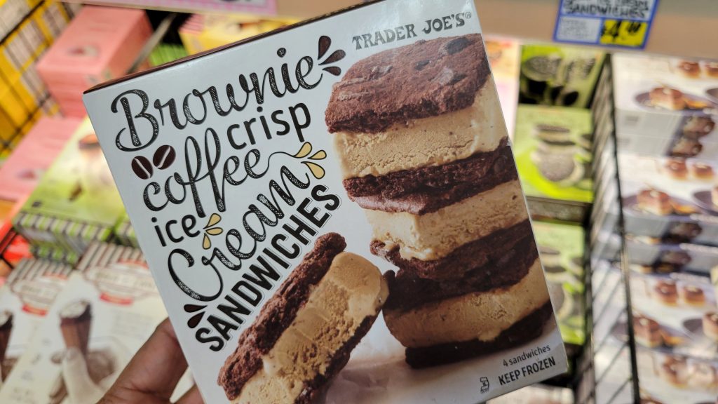 hand holding a box of trade joe's brownie crisp coffee ice cream sandwiches