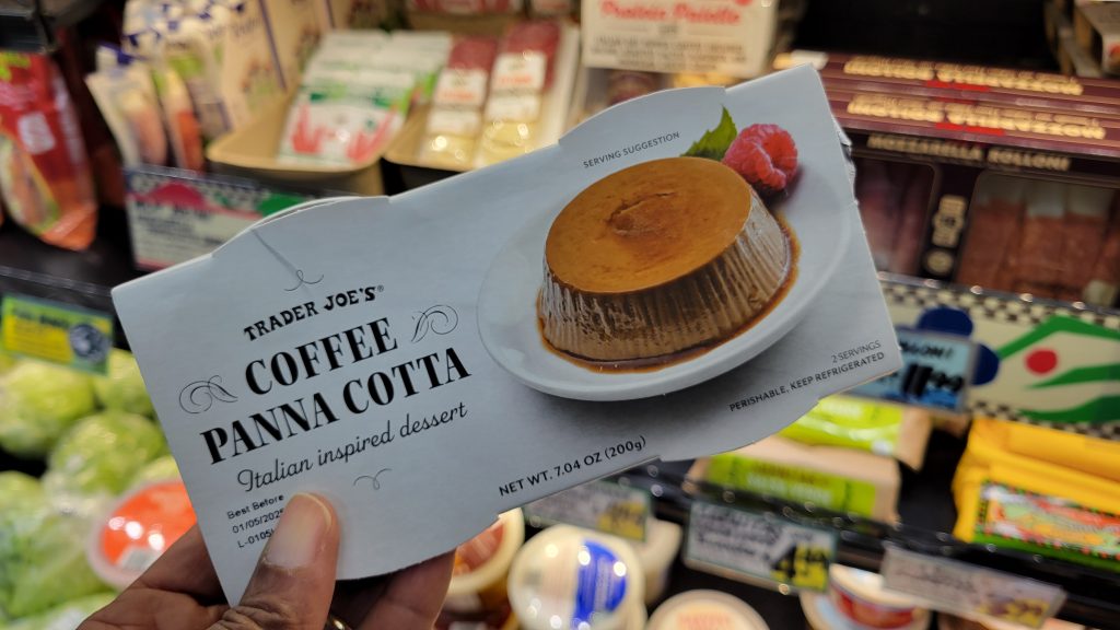 hand holding a box of trader joe's coffee panna cotta
