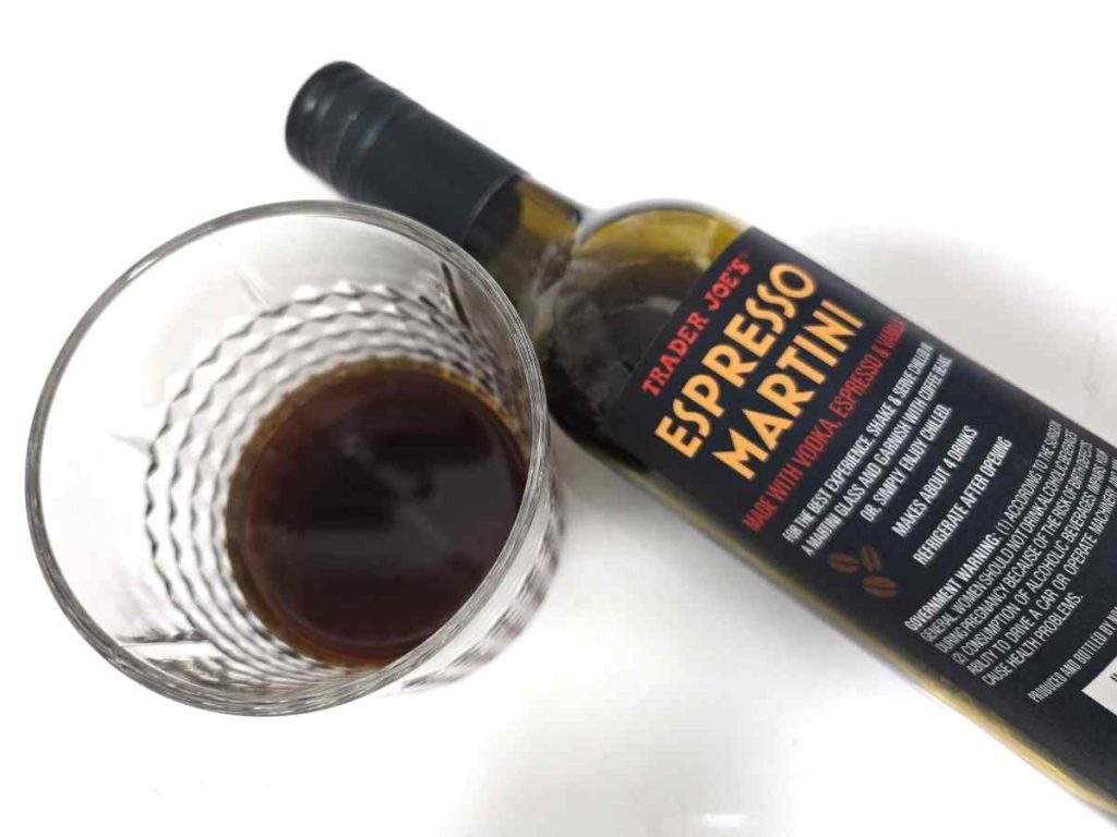 trader joes espresso martini bottle laying next to a glass