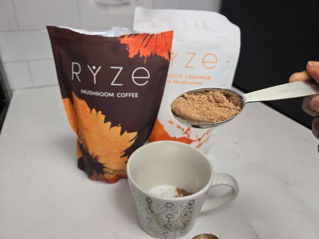 ryze coffee in a measuring spoon next to a cup