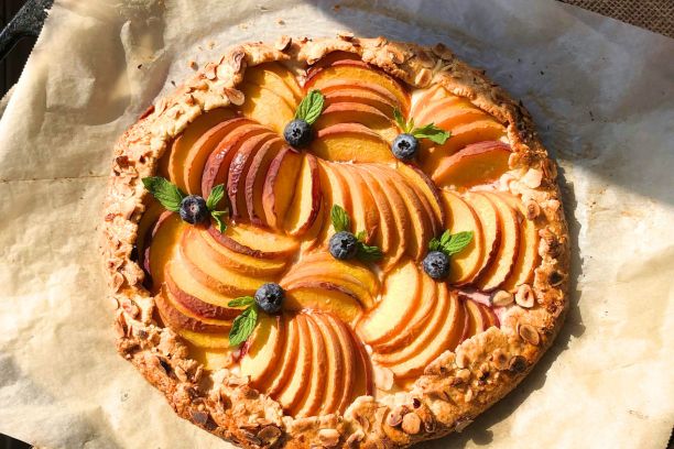 A peach galette decorated with blueberries on top