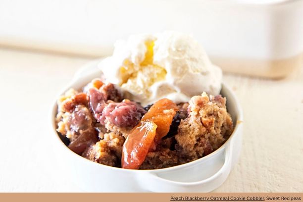 A bowl of blueberry and peach cobbler with ice cream