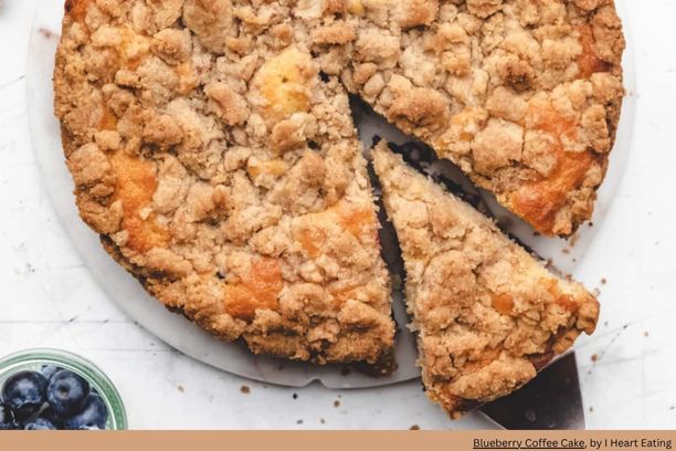 a round blueberry coffee cake with a carved slice