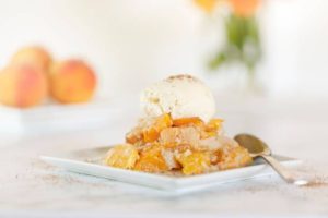 A plate of fruit dessert with a scoop of ice cream