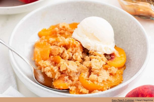 A bowl of peach cobbler with a scoop of ice cream