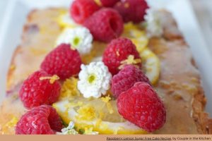 raspberries and white florals on a coffee cake