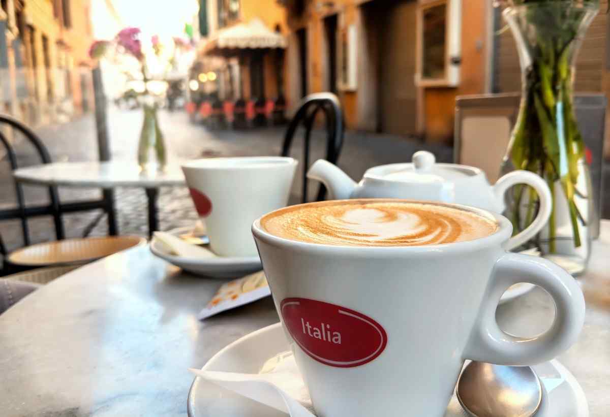 two cups of coffee sitting on a table at an outdoor cafe in Italy
